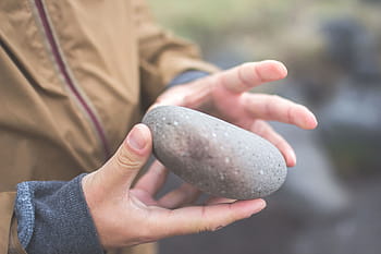 manos agarrando una piedra